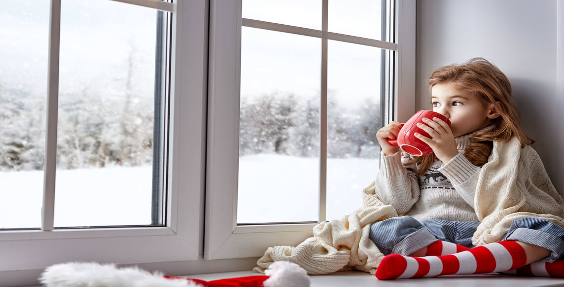 bambina che guarda fuori dalla finestra grazie al comfort abitativo